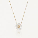 Collier en acier inoxydable: pendentif fleur en nacre irisée avec diamant central, chaîne dorée à billes blanches.