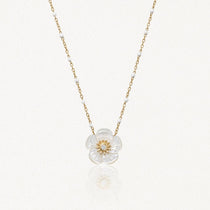 Collier en acier inoxydable: pendentif fleur en nacre irisée avec diamant central, chaîne dorée à billes blanches.