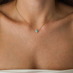 Collier fin en acier inoxydable doré avec pendentif trèfle en Amazonite sur un décolleté.