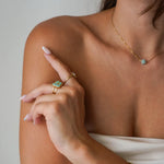 Collier fin en acier inoxydable doré avec pierre d'Amazonite turquoise clair, porté sur un décolleté.