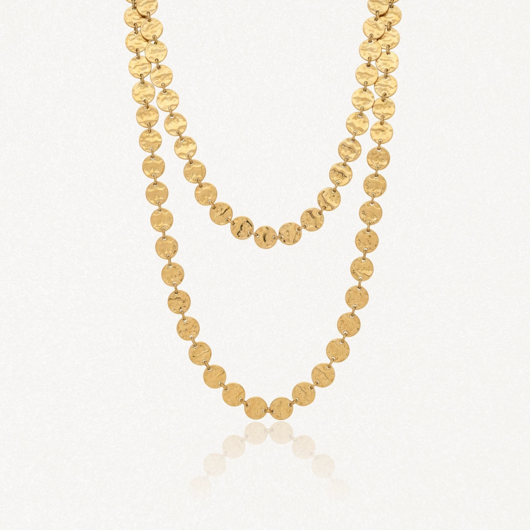 Collier long en acier inoxydable doré, composé de disques ronds martelés, élégamment drapé en deux rangs.