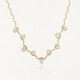 Collier en acier inoxydable dore, chaîne vague avec 9 zircons multiformes (ovales, poire, rectangulaires, carrés) sertis