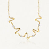 Collier ondulé en acier inoxydable doré avec quatre zircons brillants