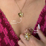 Collier en acier inoxydable doré avec pendentif fleur et perle centrale, porté sur une tenue rose.