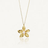 Collier en acier inoxydable doré avec pendentif fleur texturé et une perle au centre.