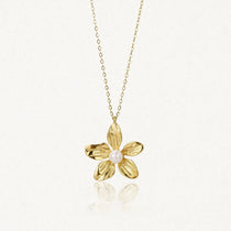 Collier en acier inoxydable doré avec pendentif fleur texturé et une perle au centre.