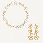Coffret ARYA en acier inoxydable doré : un collier de fleurs reliées et des boucles d'oreilles pendantes à trois fleurs.