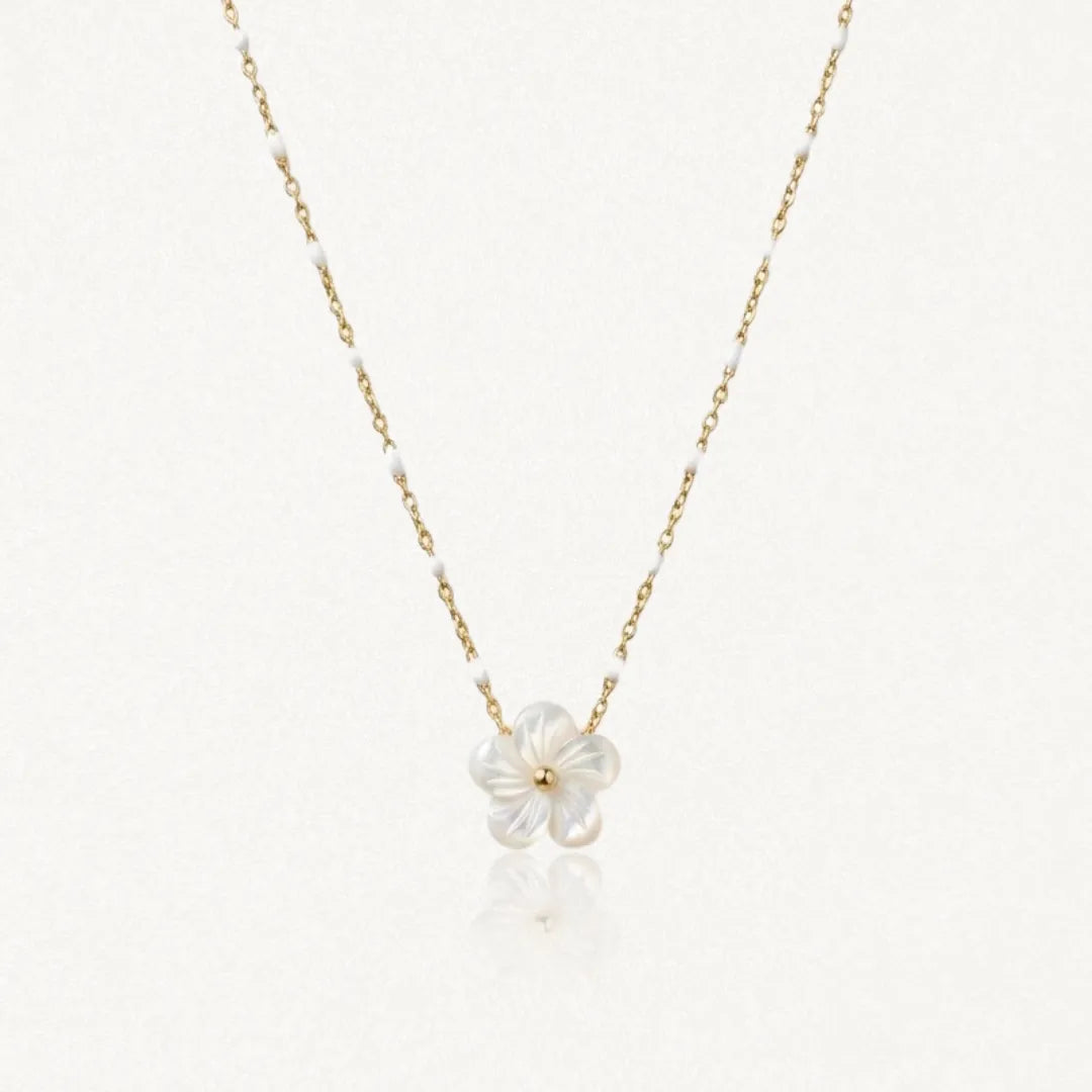 Collier maille perlée en acier inoxydable doré orné de petites perles blanches et d'un pendentif fleur en nacre.