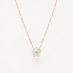 Collier maille perlée en acier inoxydable doré orné de petites perles blanches et d'un pendentif fleur en nacre.