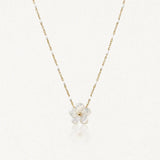 Collier maille perlée en acier inoxydable doré orné de petites perles blanches et d'un pendentif fleur en nacre.