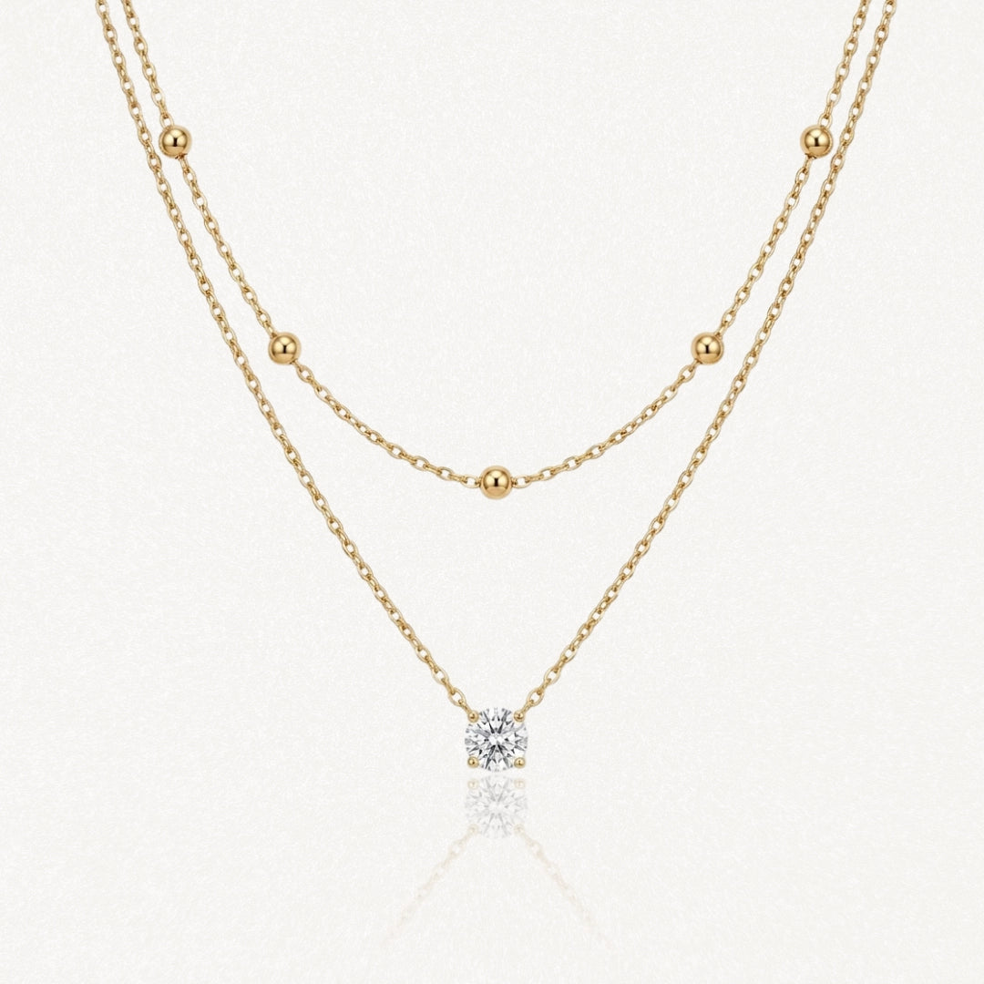 Collier double superposé en acier inoxydable doré avec chaîne à billes et pendentif pierre brillante.