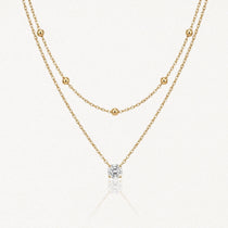 Collier double superposé en acier inoxydable doré avec chaîne à billes et pendentif pierre brillante.