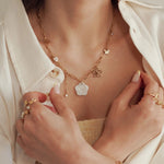 collier en acier inoxydable doré, chaîne à maillons, avec pendentifs fleur en nacre, papillons, perles et cristaux.