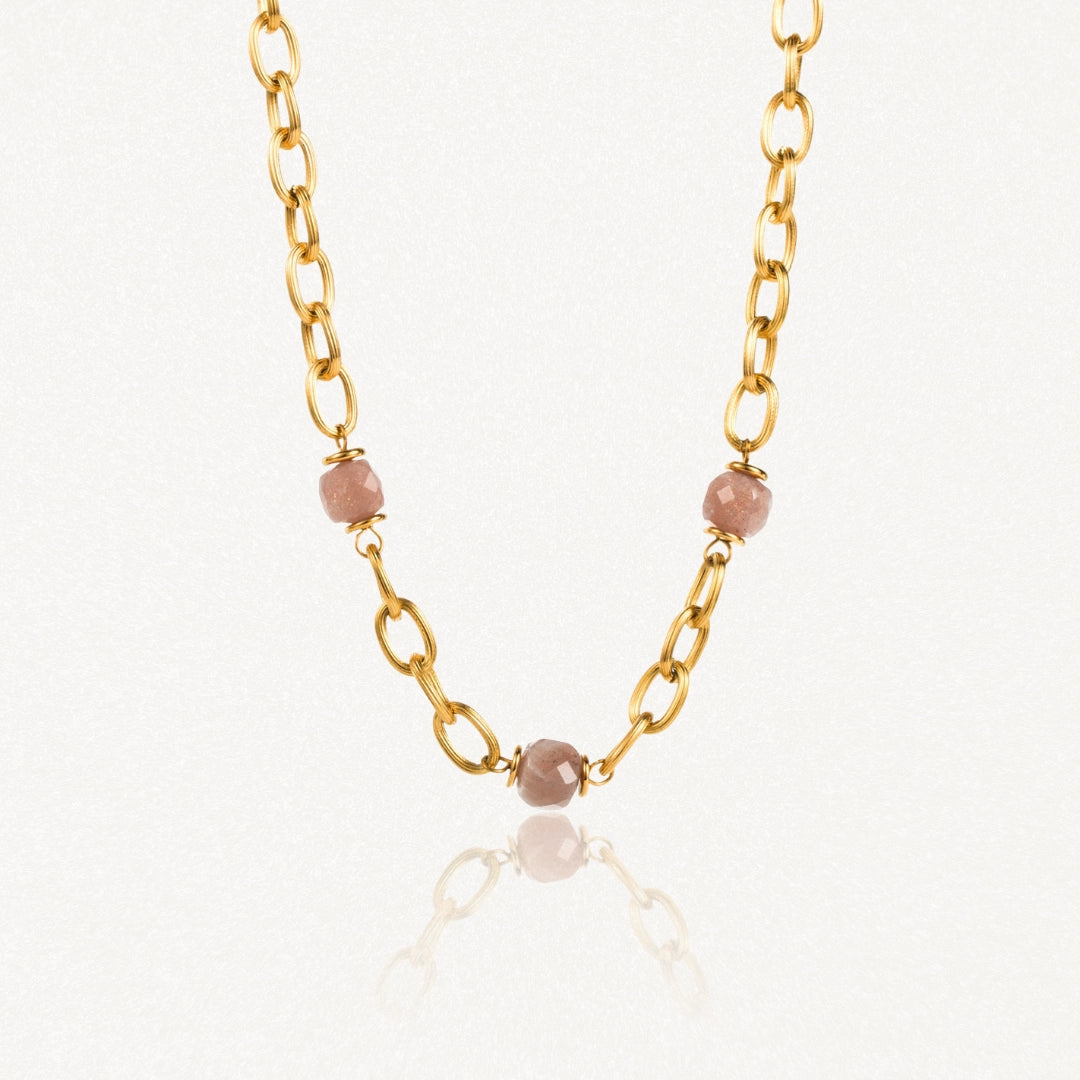 Collier en acier inoxydable doré à gros maillons ovales avec 3 perles facetées rose pâle.