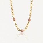 Collier en acier inoxydable doré à gros maillons ovales avec 3 perles facetées rose pâle.