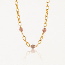 Collier en acier inoxydable doré à gros maillons ovales avec 3 perles facetées rose pâle.