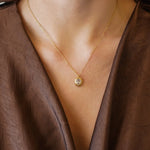 Collier Kendall en acier inoxydable doré avec un pendentif ovale orné d'un strass en zirconium porté au cou