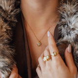 Collier Kendall en acier inoxydable doré avec un pendentif ovale orné d'un strass en zirconium porté au cou