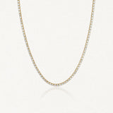 Collier rivière tennis en acier inoxydable doré, entièrement serti de zircons clairs.