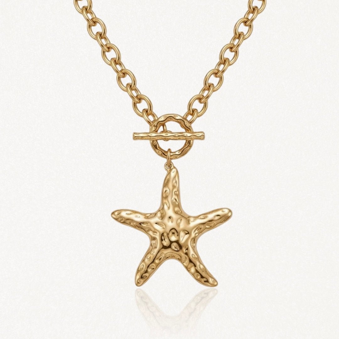 Collier en acier inoxydable doré avec chaîne maillons, fermoir toggle et pendentif étoile de mer texturée.
