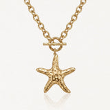 Collier en acier inoxydable doré avec chaîne maillons, fermoir toggle et pendentif étoile de mer texturée.