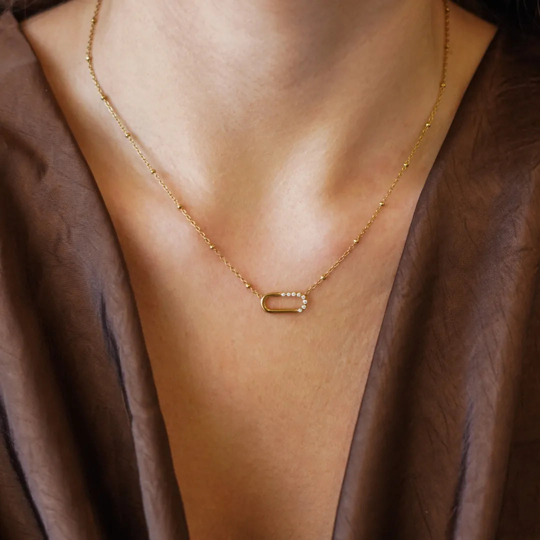 Collier Kylie en acier inoxydable doré avec une fine chaîne à billes et un pendentif ovale orné de strass zirconium