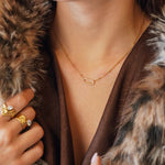 Collier Kylie en acier inoxydable doré avec un pendentif ovale orné de strass en zirconium porté au cou