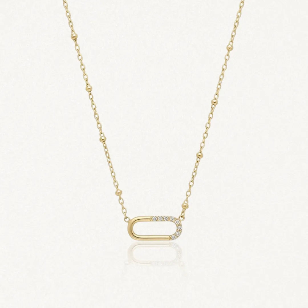 Collier Kylie en acier inoxydable doré avec une chaîne à billes et un pendentif ovale orné de petits strass zircon