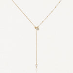 Collier lariat en acier inoxydable doré avec perles, petits détails dorés et zircon. Pendentif chaîne avec perle finale.