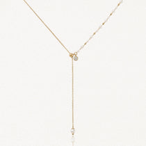 Collier lariat en acier inoxydable doré avec perles, petits détails dorés et zircon. Pendentif chaîne avec perle finale.