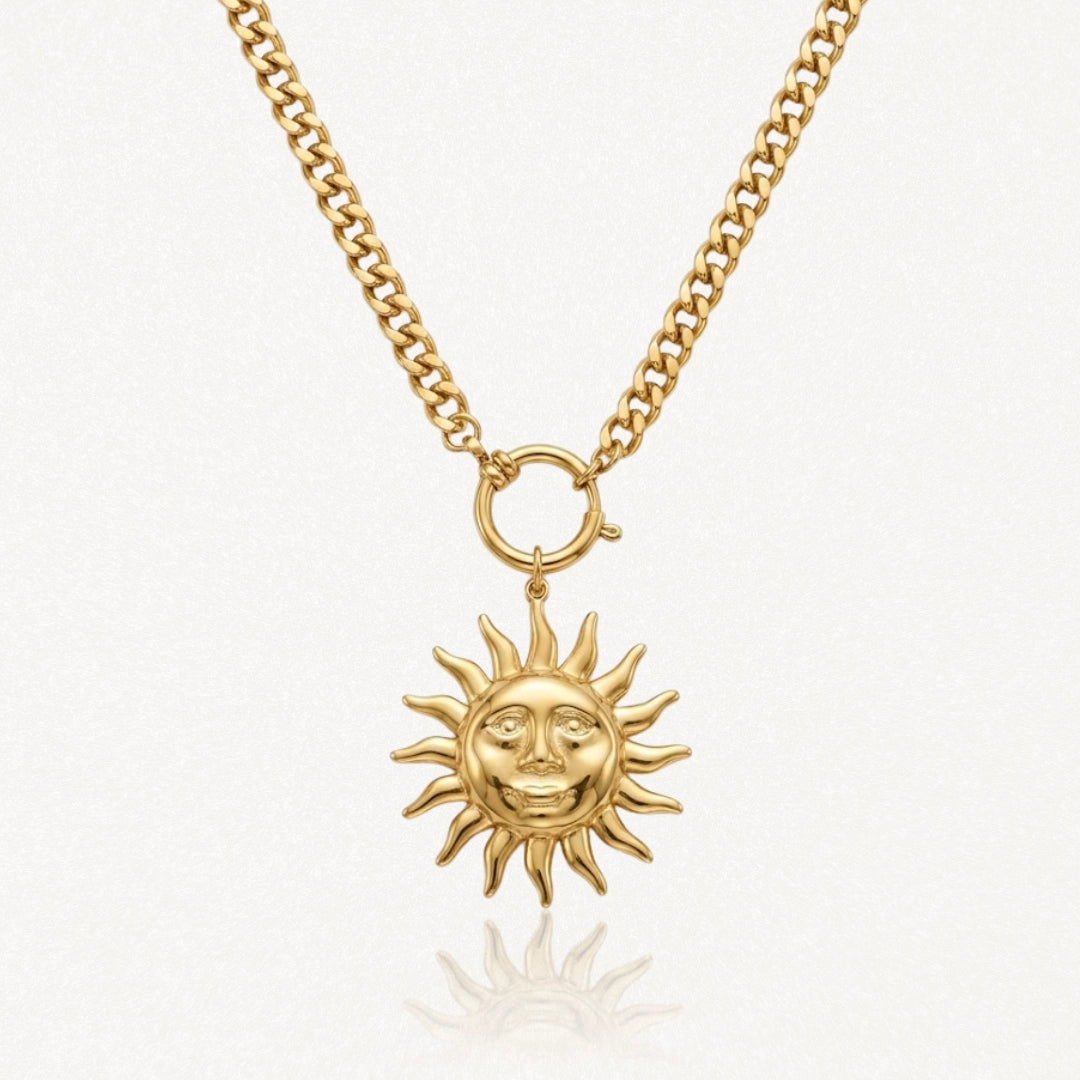 Collier acier inoxydable doré, chaîne gourmette et pendentif soleil stylisé avec visage souriant.