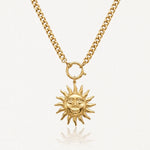 Collier acier inoxydable doré, chaîne gourmette et pendentif soleil stylisé avec visage souriant.