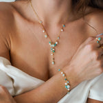 Collier en Y en acier inoxydable doré avec breloques d'amazonite et perles d'eau douce porté sur un décolleté.