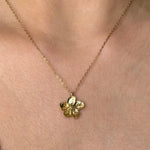Collier en acier inoxydable doré avec un pendentif fleur détaillé. La chaîne fine et le pendentif sont portés sur le