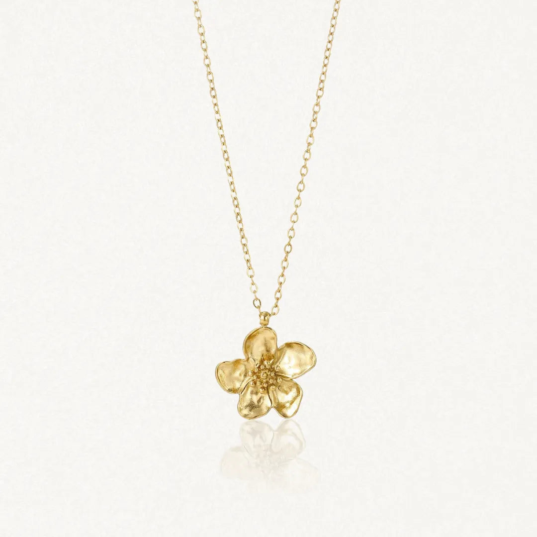 Collier en acier inoxydable doré avec un pendentif fleur aux pétales légèrement texturés.