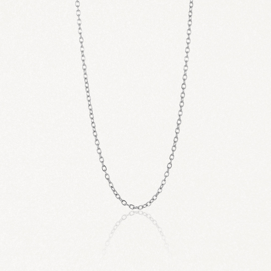 Collier chaîne en acier inoxydable à mailles ovales, couleur argenté, sur fond blanc avec reflet.
