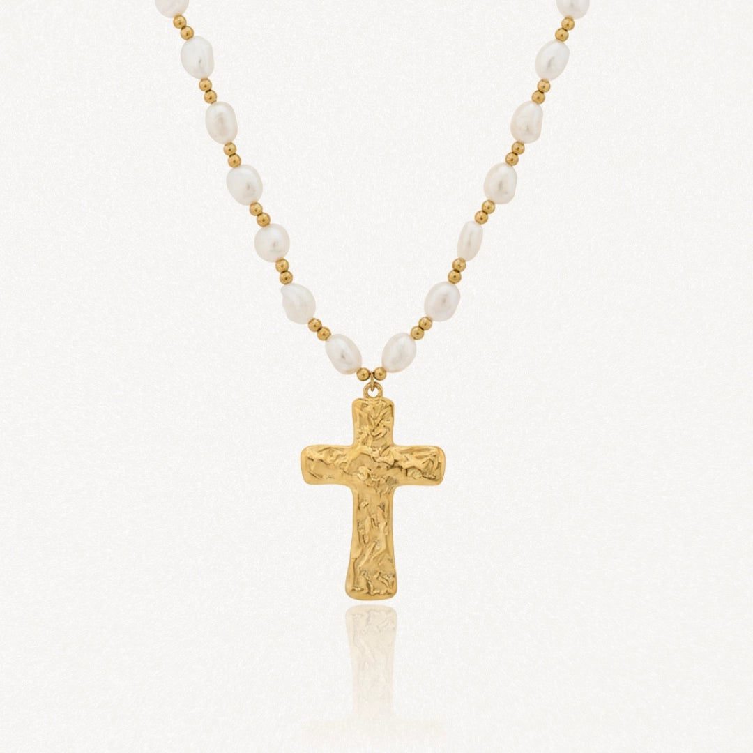 Collier en acier inoxydable, perles de culture blanches irrégulières et croix dorée texturée.