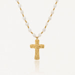 Collier en acier inoxydable, perles de culture blanches irrégulières et croix dorée texturée.