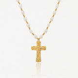 Collier en acier inoxydable, perles de culture blanches irrégulières et croix dorée texturée.