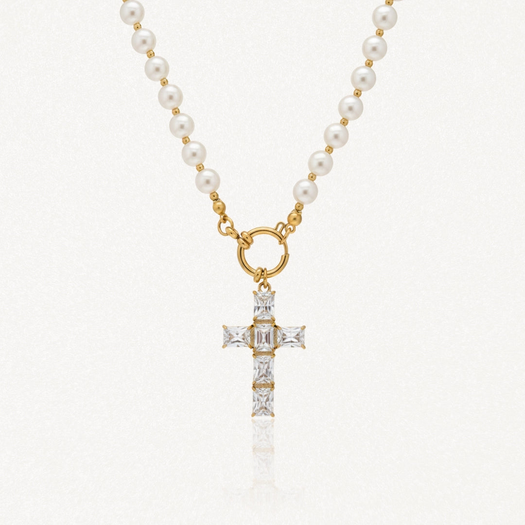 Collier en acier inoxydable doré avec perles blanches, pendentif croix orné de pierres transparentes rectangulaires.