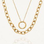 Double collier doré en acier inoxydable. Il se compose d'une chaîne épaisse à maillons ovales et d'une chaîne fine avec un pendentif anneau lisse.