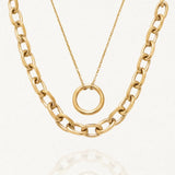 Double collier doré en acier inoxydable. Il se compose d'une chaîne épaisse à maillons ovales et d'une chaîne fine avec un pendentif anneau lisse.
