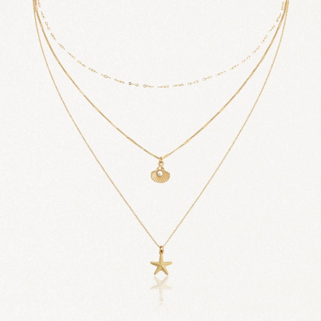 Collier 3 rangs en acier inoxydable doré, pendentifs étoile de mer et coquillage perlé.