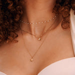 Collier en acier inoxydable doré: 3 chaînes superposées avec perles blanches, pendentifs coquillage perle et étoile de mer.