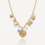 Collier en acier inoxydable doré, multiples pendentifs cœurs sacrés et texturés, perles et charms bleu/blanc.