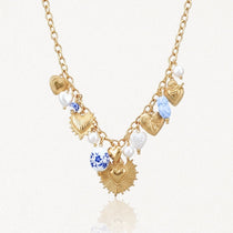 Collier en acier inoxydable doré, multiples pendentifs cœurs sacrés et texturés, perles et charms bleu/blanc.
