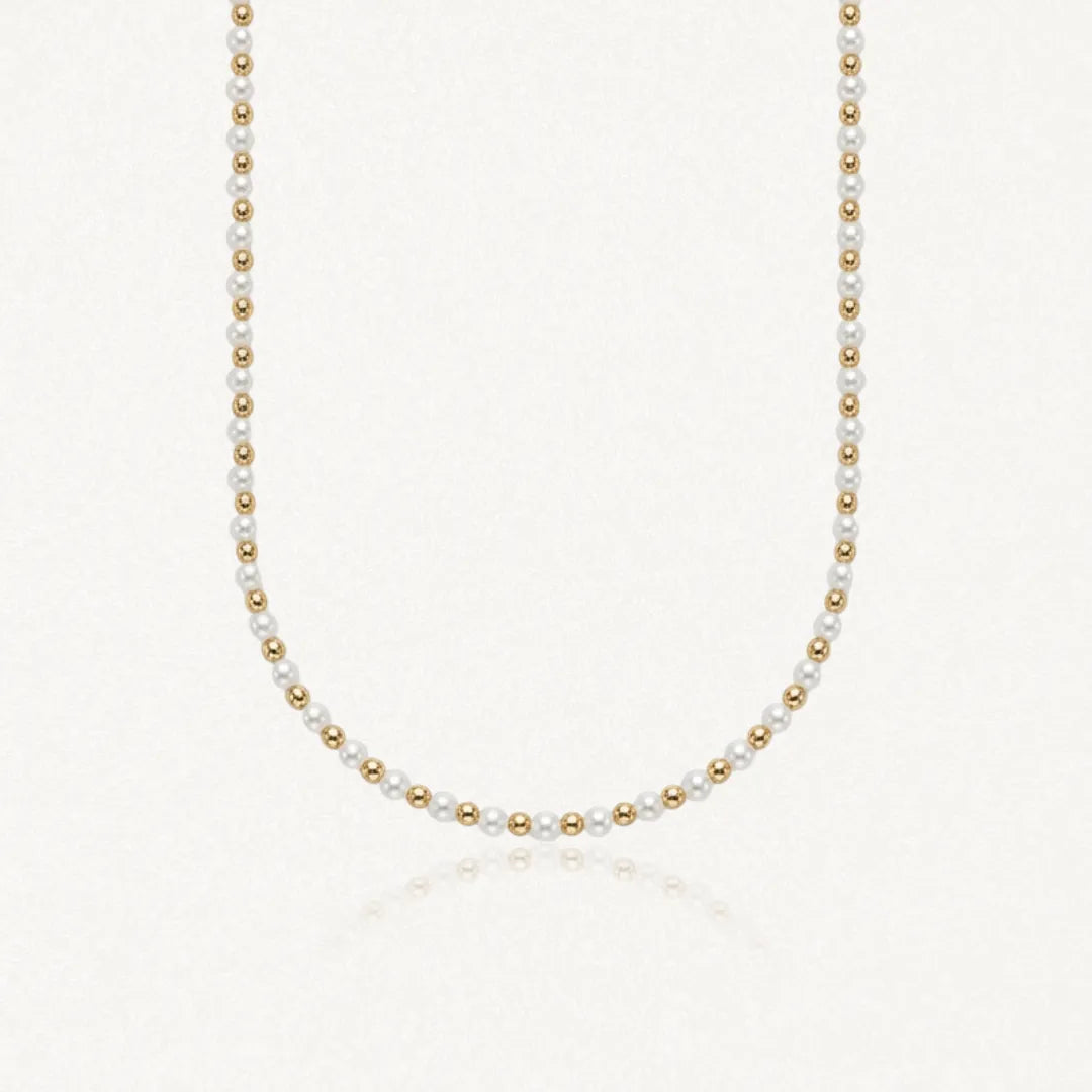Collier ras-de-cou en perles blanches alternées de billes rondes en acier inoxydable doré.