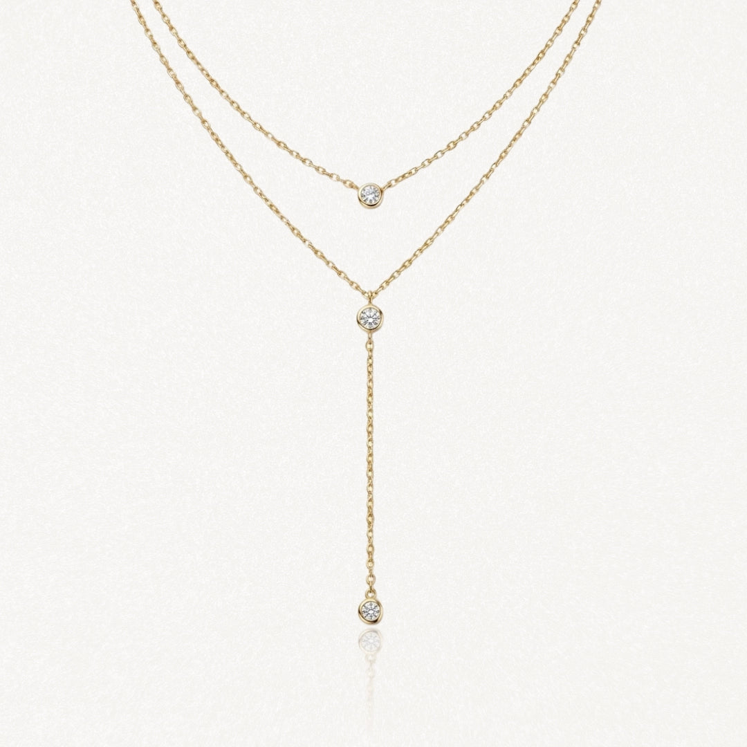 Collier double rang en acier inoxydable doré, type lariat, orné de 3 pendentifs zircon ronds brillants.