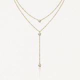 Collier double rang en acier inoxydable doré, type lariat, orné de 3 pendentifs zircon ronds brillants.