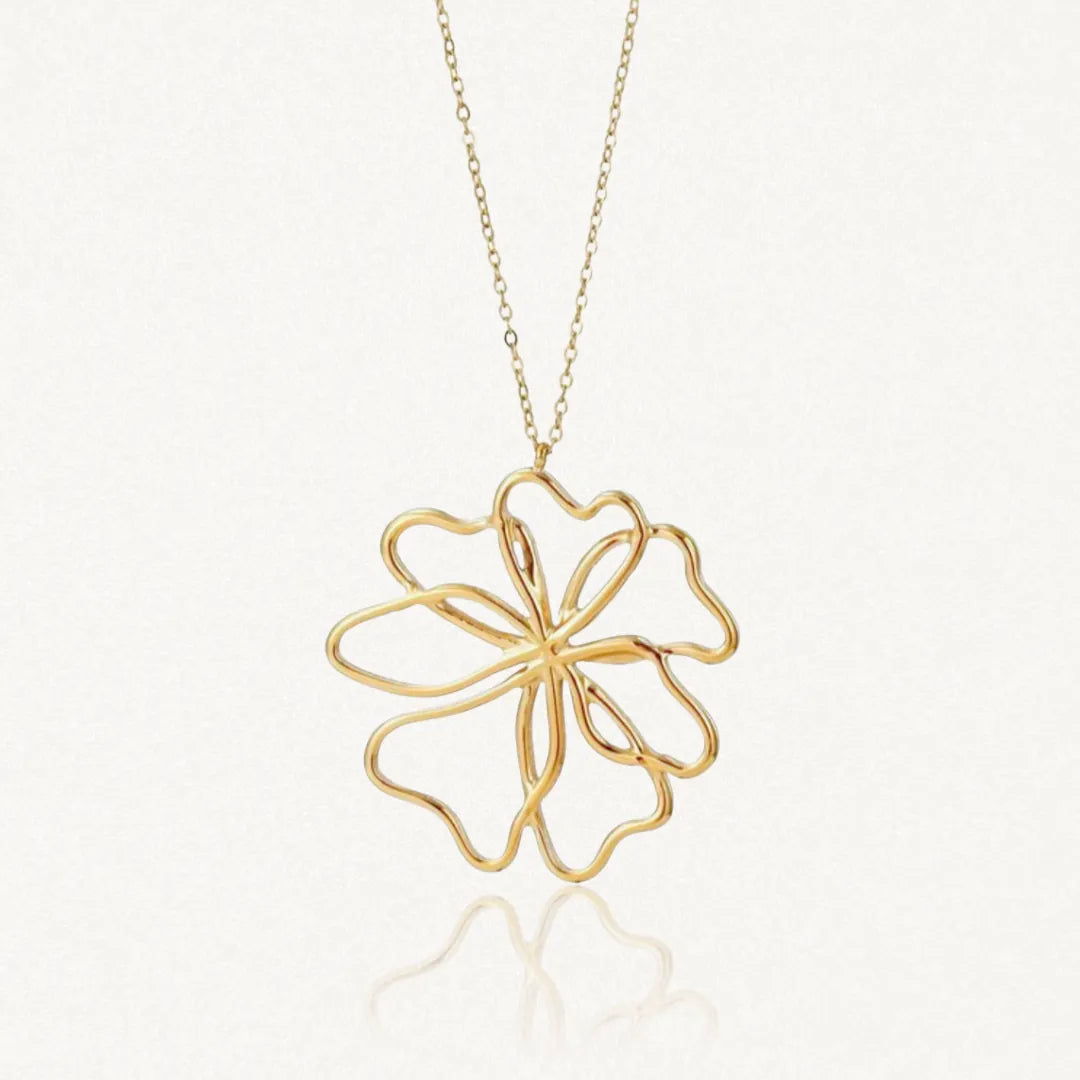 Collier en acier inoxydable dore, pendentif grande fleur ajouree aux petales courbes et stylises.